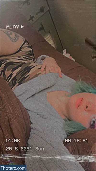 cutelittlemama - there is a woman with green hair laying on a bed