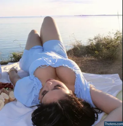 Reema Balouch - laying on a blanket with a stuffed bear on the beach