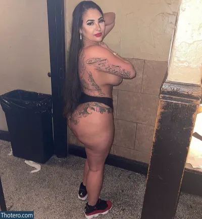Jay King - woman with tattoos on her body standing in a bathroom