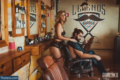 Fabi Guedes - man sitting in a barber chair with a woman in a bikini