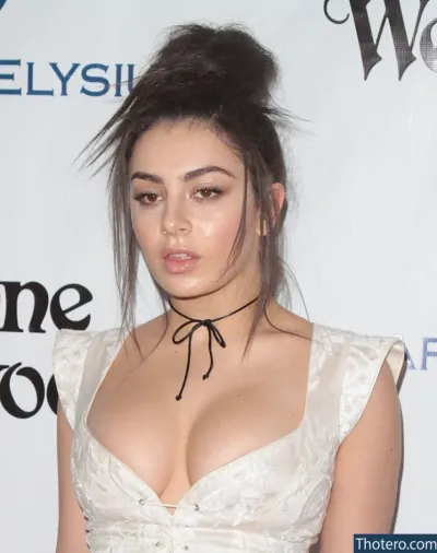 Charlie XCX - a close up of a woman in a white dress posing for a picture