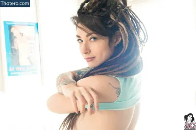 Alerose - woman with dreads and tattoos posing for a picture