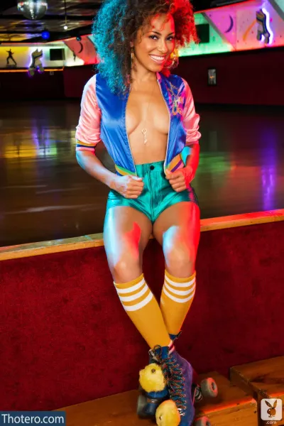 Shanice Jordyn - woman in a colorful outfit sitting on a skateboard