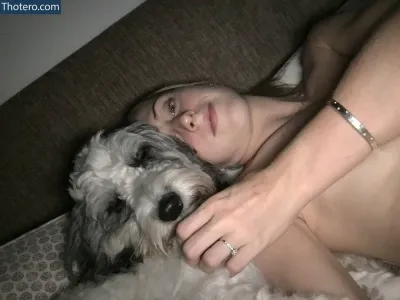Laura Trott - woman laying on a couch with a dog on her lap